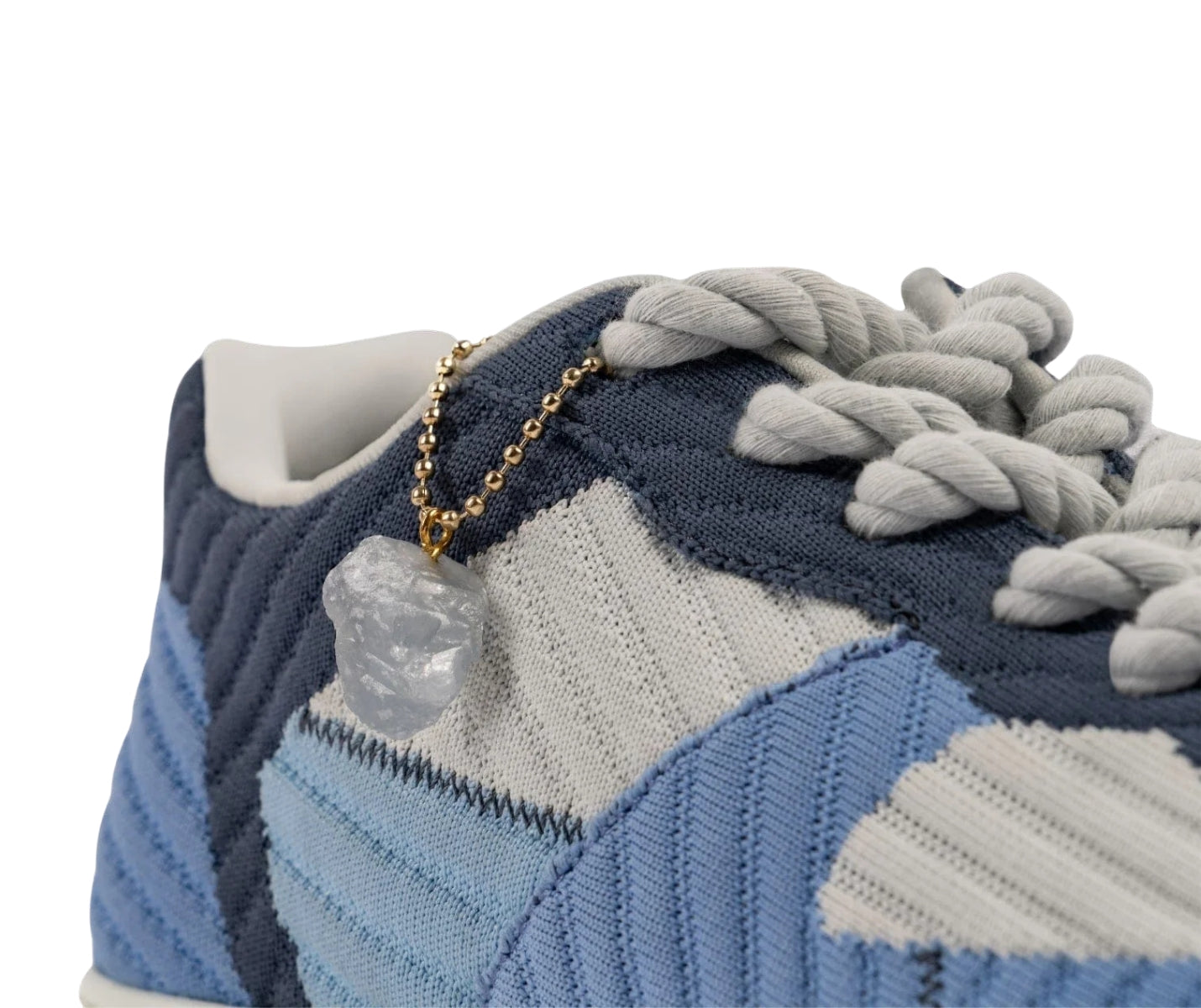 Nahaufnahme der Fuego Jade Dance Sneakers in Blau mit weißen Schnürsenkeln und einem Kristallanhänger.